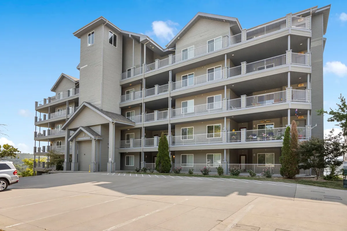 This image presents another angle of the building’s main entrance, with landscaped greenery and balconies visible. It conveys an inviting, safe atmosphere and showcases the property’s curb appeal, contributing to the sense of security and a high-quality experience.