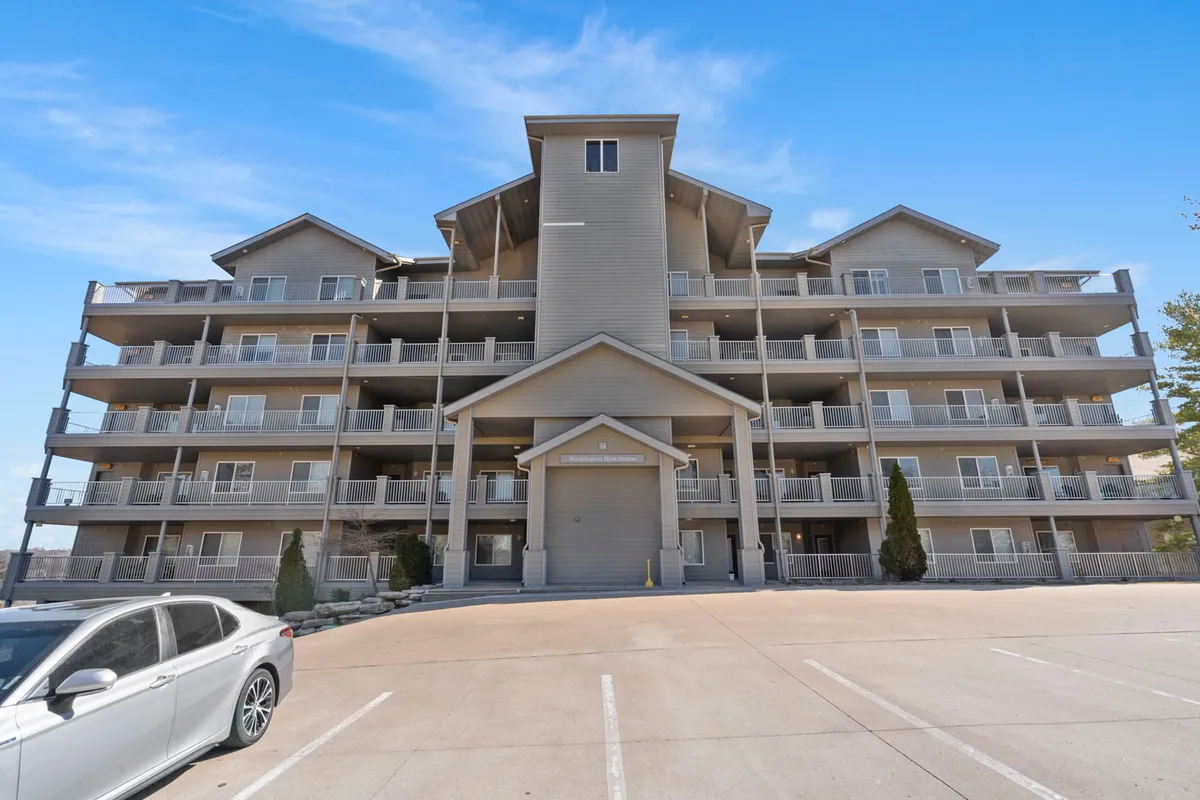 The image shows the exterior facade of Treehouse 1402, with a clear view of the central entrance and multiple balconies. The setting is welcoming and hints at communal and family-friendly activities, as well as opportunities for relaxing outdoors, such as enjoying sunset views from the balconies.