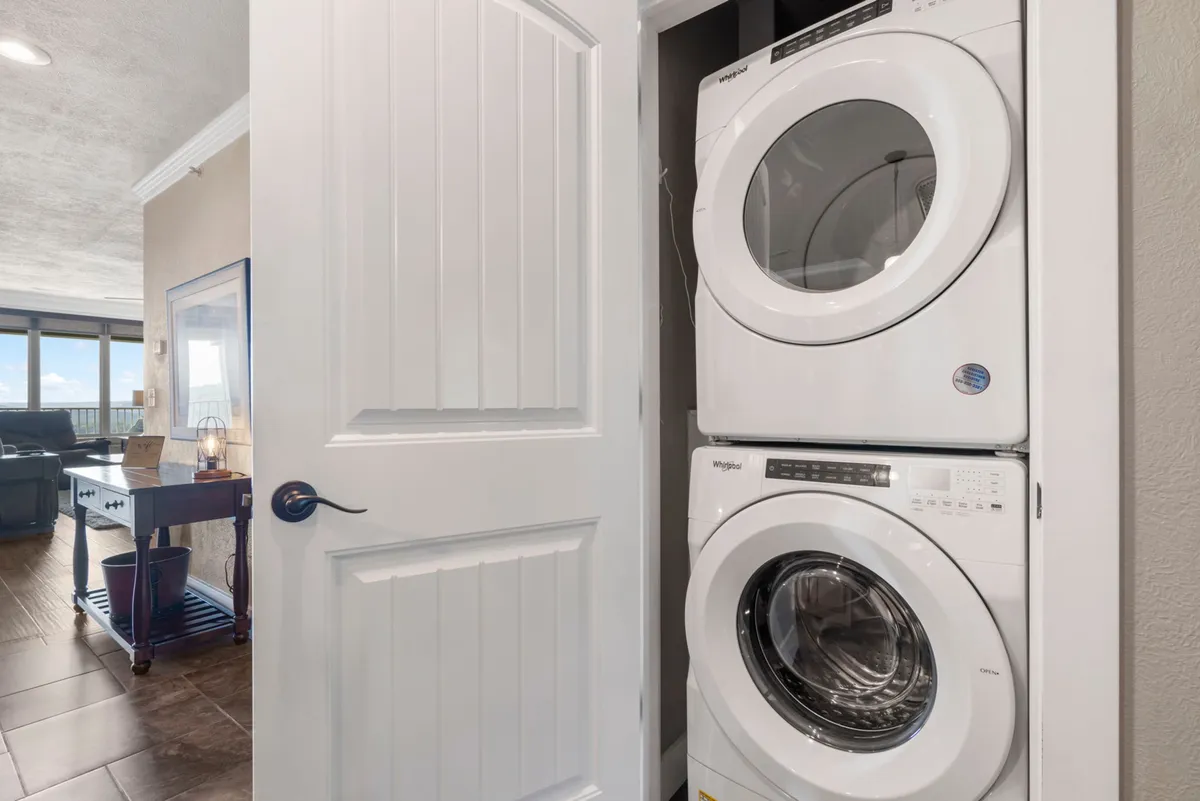A practical and cozy laundry area featuring a washer and dryer, with a door leading to another part of the home. The space is efficiently organized, making daily routines easier for families and longer stays.